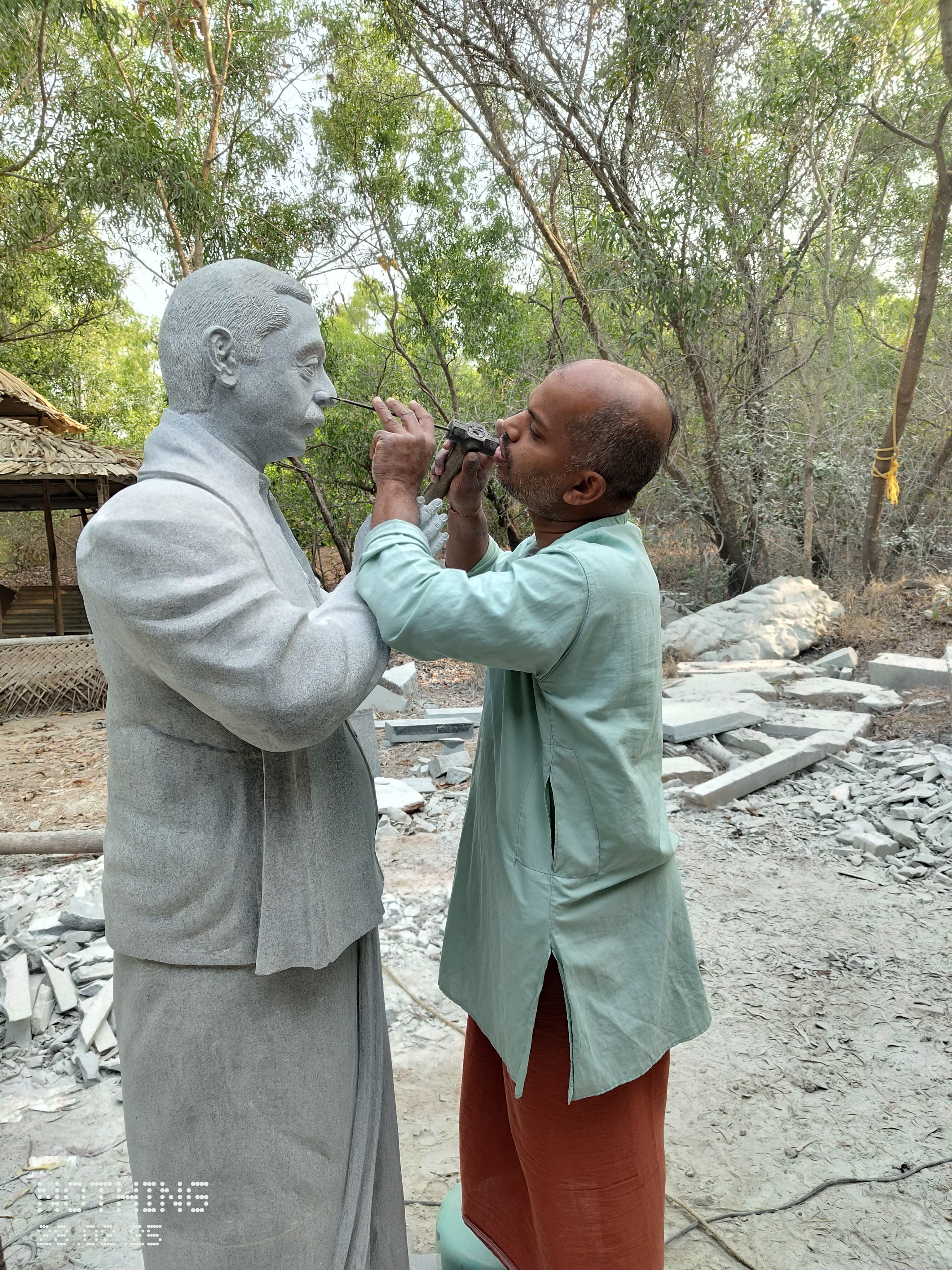 Sri Chidananda Acharya at work on a life-size realistic stone statue