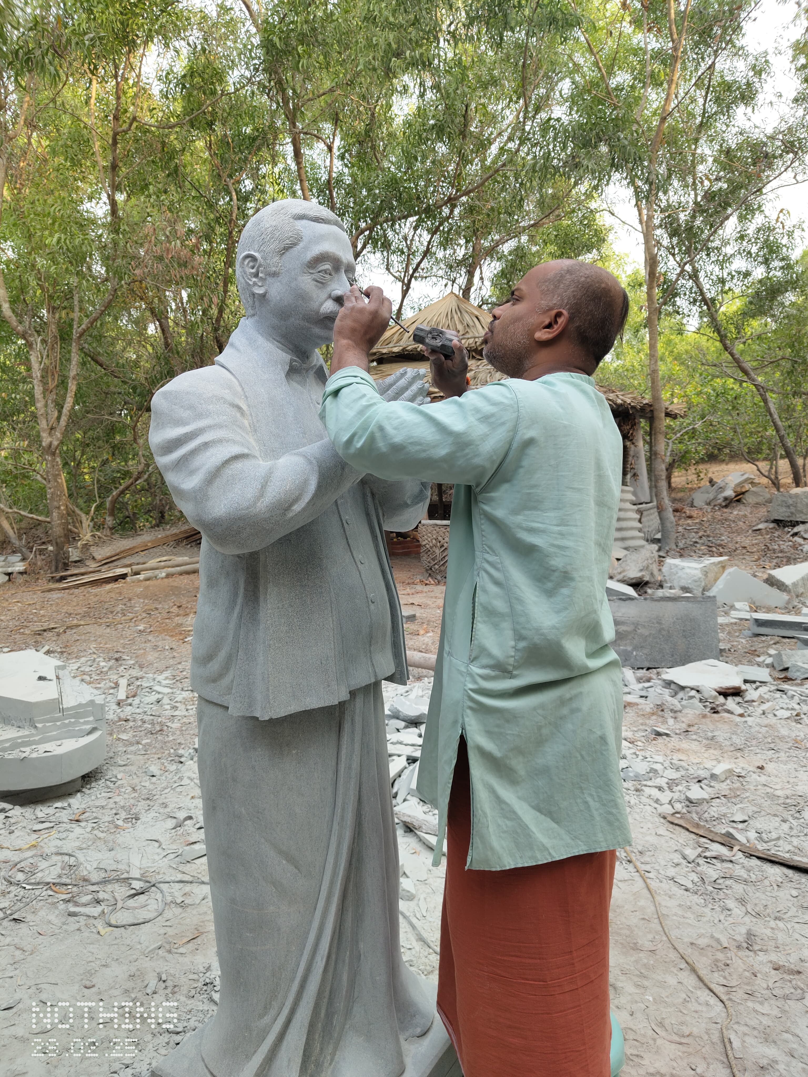 Sri Chidananda Acharya carving a detailed realistic face on a life-size granite portrait